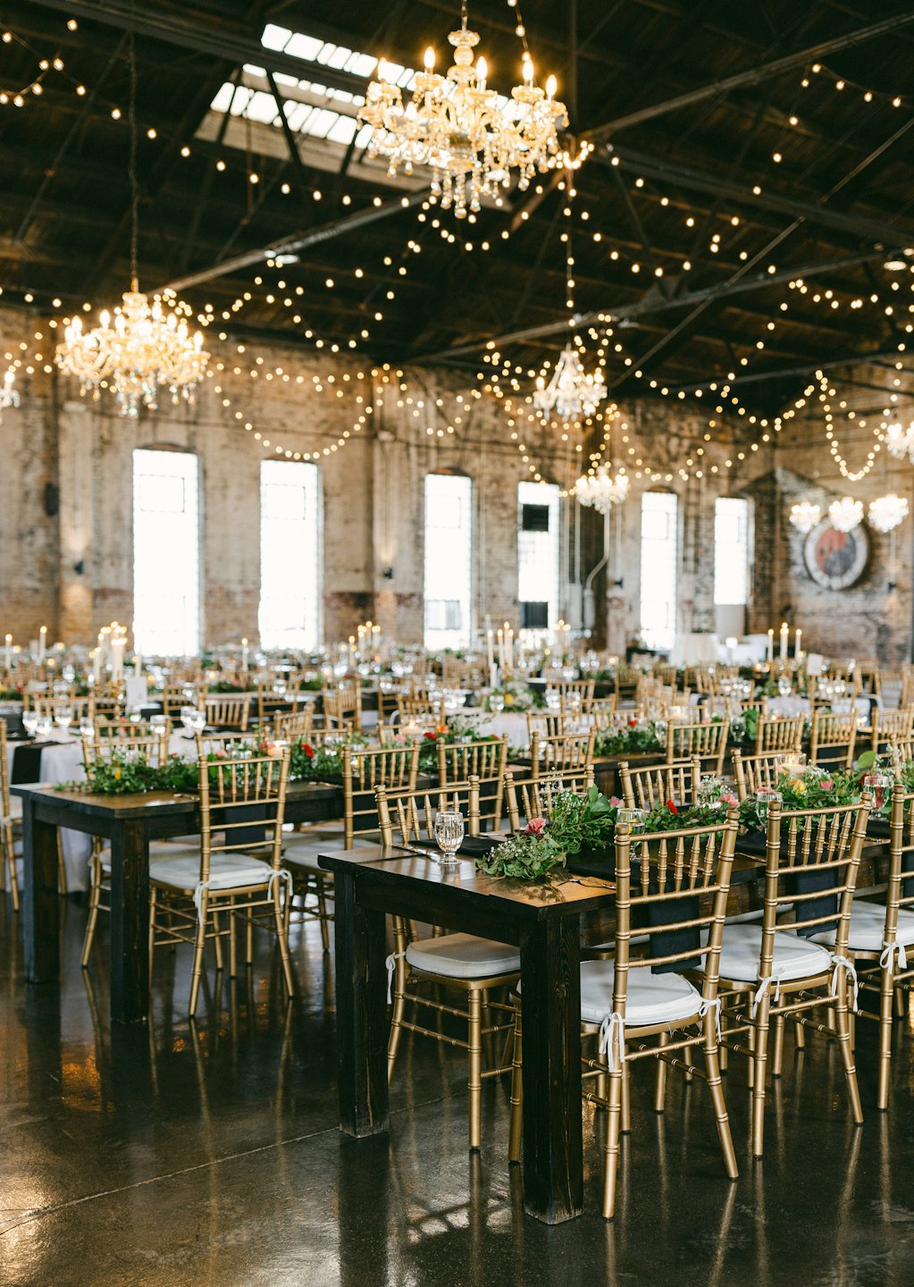 Wedding reception tables with candles and floral arrangements.