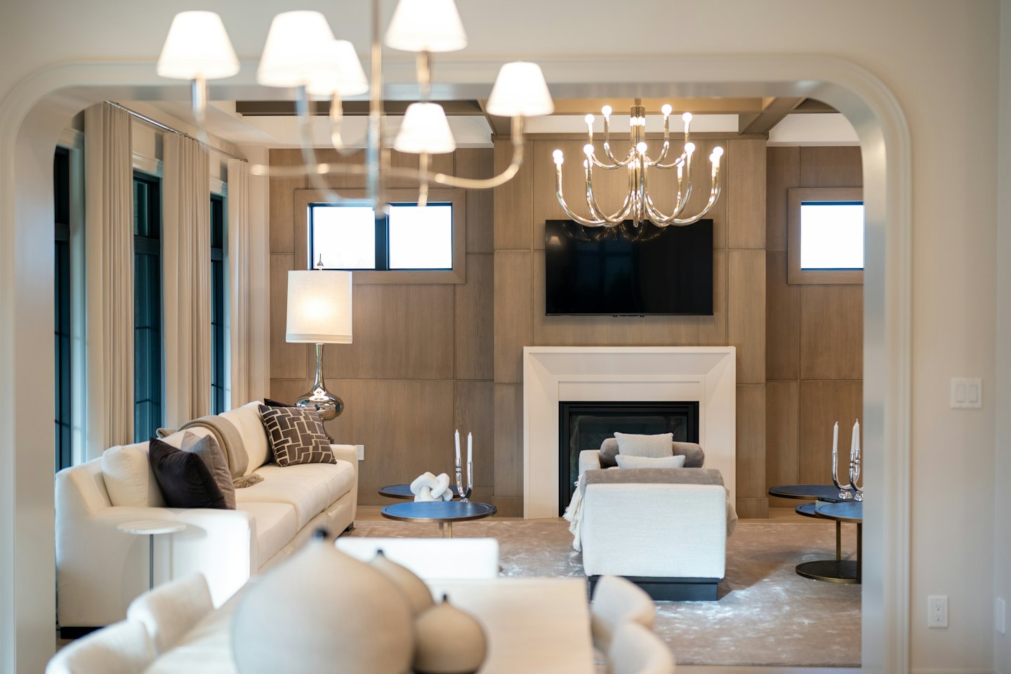 Modern living room with cream sofas around a fireplace.