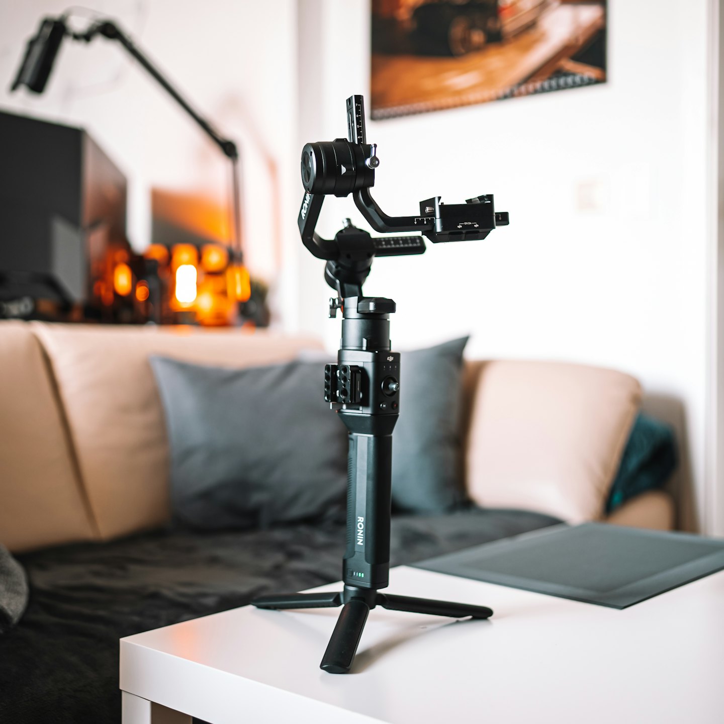 Black camera gimbal standing on a white table.